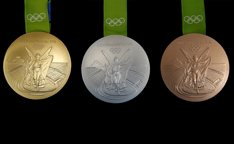 A sculptress from the Brazilian Mint works on the Olympic medals at her computer.
![Firstpost
